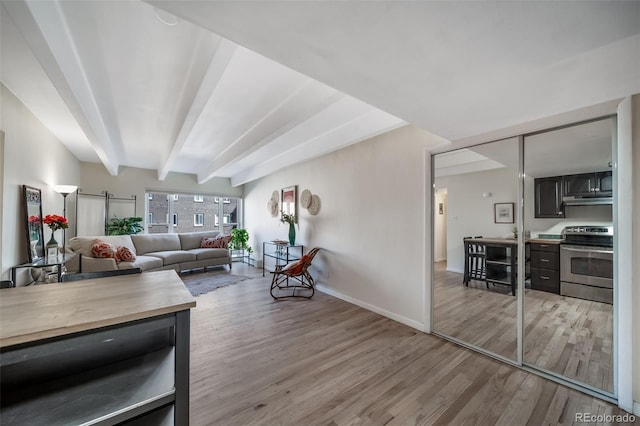 living room with baseboards, beam ceiling, and light wood finished floors