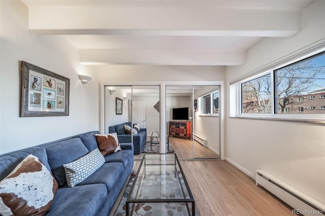 living area featuring baseboards, light wood finished floors, a baseboard heating unit, beamed ceiling, and baseboard heating