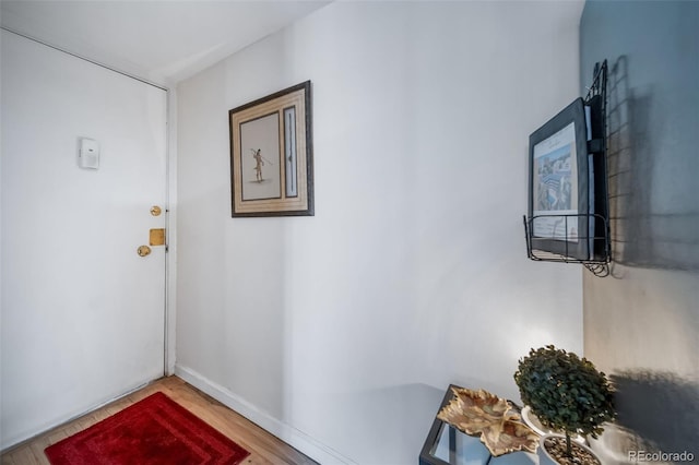 hall featuring baseboards and wood finished floors