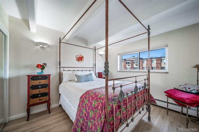 33 N Corona St Unit 205, Denver, CO 80218 - bedroom featuring wood finished floors, a baseboard radiator, and baseboards