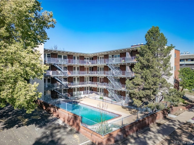 33 N Corona St Unit 205, Denver, CO 80218 - view of apartment building / complex with a community pool, fence, and stairway