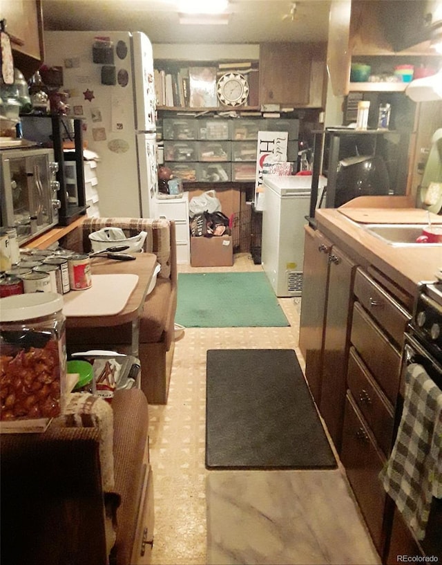 kitchen featuring black stove and washer / clothes dryer