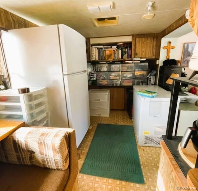 10795 County Road 197 A Unit 105, Nathrop, CO 81236 - kitchen featuring tile patterned floors, washer / dryer, freestanding refrigerator, and brown cabinets