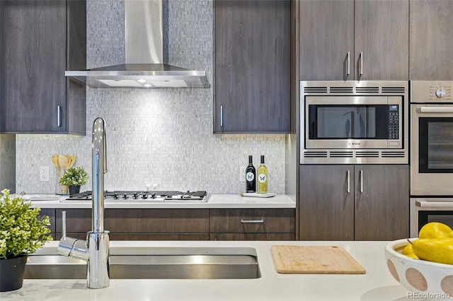 250 Columbine St Unit 310, Denver, CO 80206 - kitchen featuring wall chimney range hood, appliances with stainless steel finishes, and dark brown cabinetry