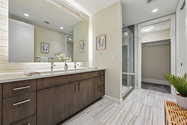 250 Columbine St Unit 310, Denver, CO 80206 - full bathroom with double vanity, a stall shower, baseboards, a spacious closet, and recessed lighting