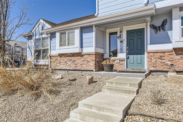 entrance to property featuring brick siding