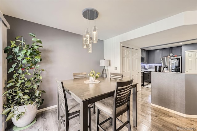 dining room featuring light wood-type flooring and baseboards