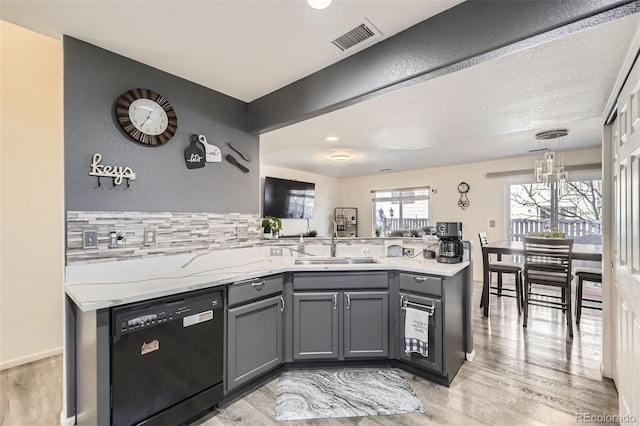 kitchen featuring visible vents, a peninsula, gray cabinets, dishwasher, and light wood-type flooring