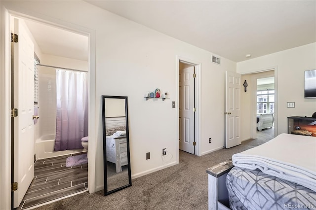 bedroom with visible vents, carpet flooring, ensuite bath, and baseboards