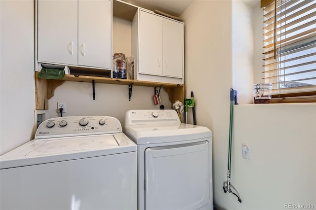 laundry area featuring washer and clothes dryer and cabinet space