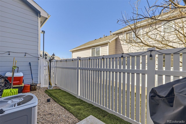 view of yard with central AC unit and fence