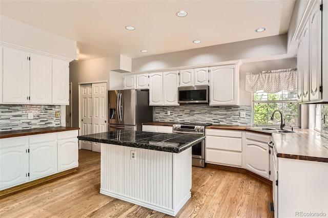 2141 Weatherstone Cir, Highlands Ranch, CO 80126 - kitchen with appliances with stainless steel finishes, a sink, white cabinetry, a kitchen island, and recessed lighting