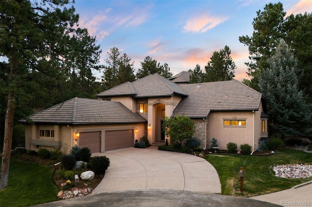 view of front of house with a garage and a yard