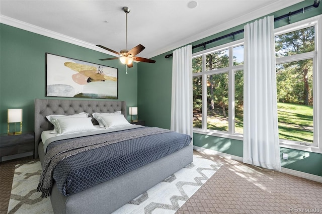 carpeted bedroom with ceiling fan, multiple windows, and ornamental molding