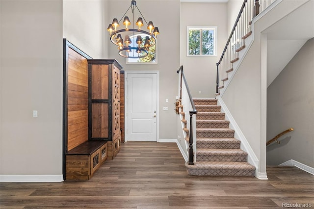 entrance foyer with a chandelier, dark hardwood / wood-style flooring, and a towering ceiling