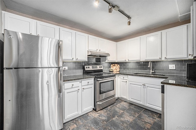 3047 W 47th Ave Unit 109, Denver, CO 80211 - kitchen featuring stainless steel appliances, under cabinet range hood, white cabinets, decorative backsplash, and dark stone countertops