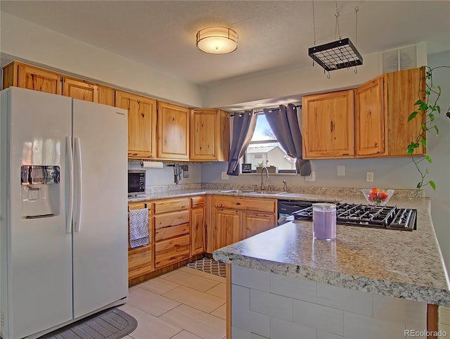 4506 Winewood Village Dr, Colorado Springs, CO 80917 - kitchen with white fridge with ice dispenser, a sink, light countertops, and stainless steel microwave