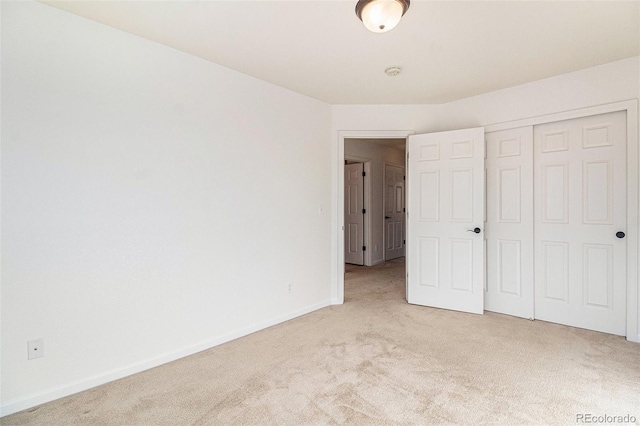 unfurnished bedroom with light carpet and a closet