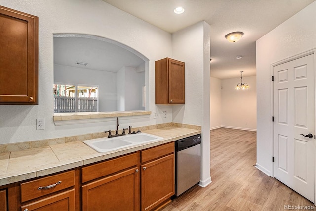 kitchen with dishwasher, sink, hanging light fixtures, light hardwood / wood-style flooring, and a notable chandelier