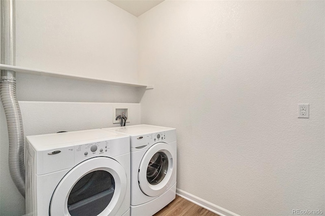 laundry area with wood-type flooring and separate washer and dryer