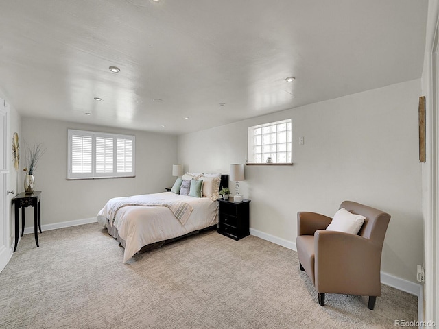 bedroom featuring baseboards, multiple windows, and light colored carpet