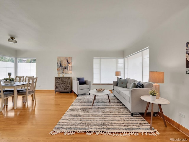 living area featuring light wood finished floors and baseboards