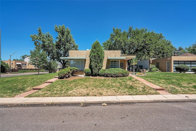 ranch-style house with brick siding and a front lawn