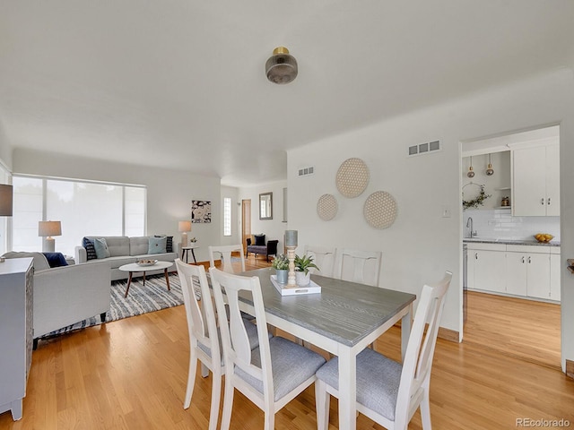 dining space with visible vents and light wood finished floors