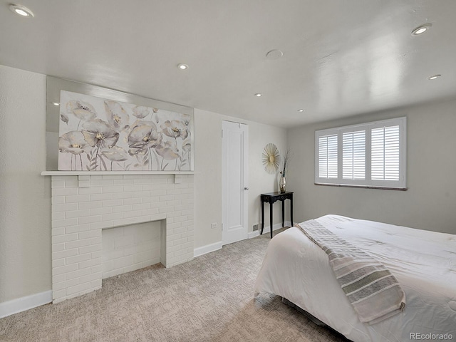 bedroom with recessed lighting, a brick fireplace, light carpet, and baseboards