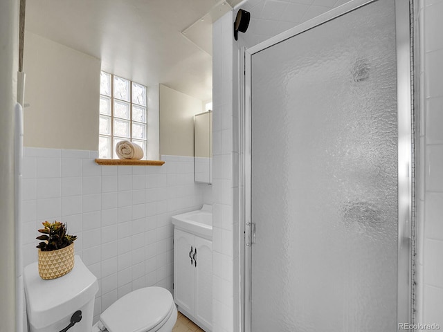 bathroom featuring toilet, a shower stall, tile walls, and vanity