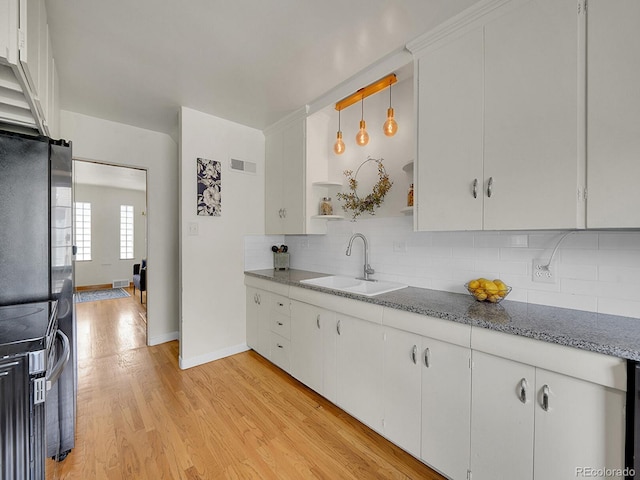 kitchen featuring open shelves, a sink, white cabinetry, and pendant lighting