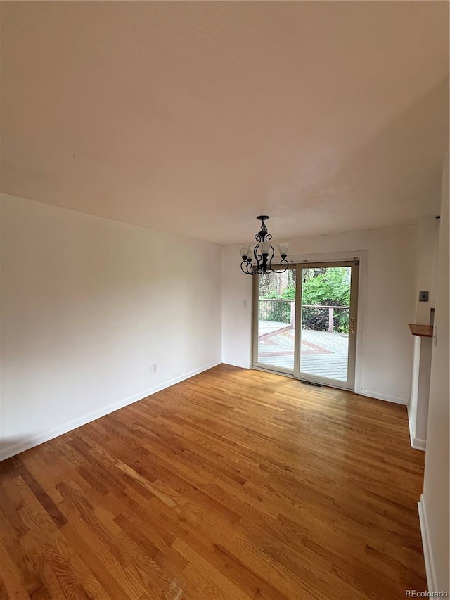 3566 E Fair Pl, Centennial, CO 80121 - empty room featuring a chandelier and light wood finished floors