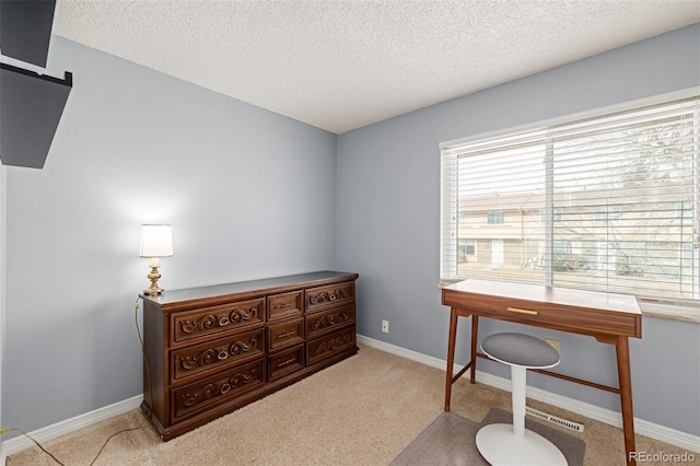 office space with light carpet and a textured ceiling