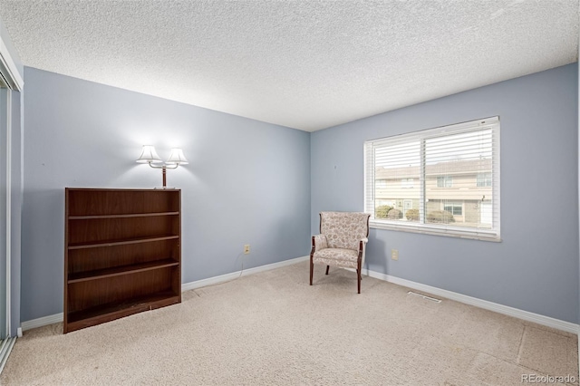 living area featuring carpet flooring and a textured ceiling