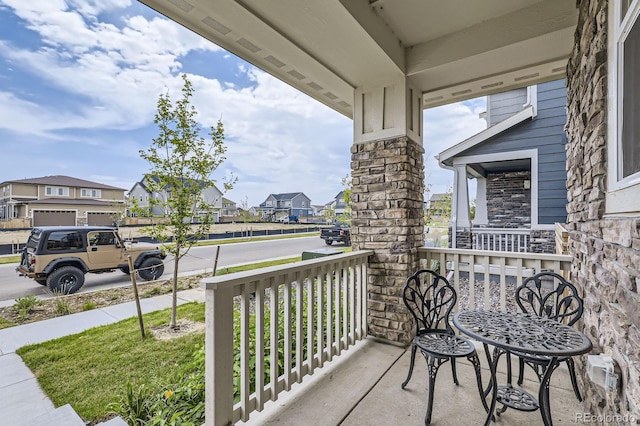 balcony featuring covered porch and a residential view