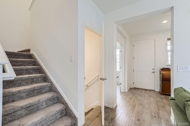 entryway featuring light wood-style floors, baseboards, and stairway