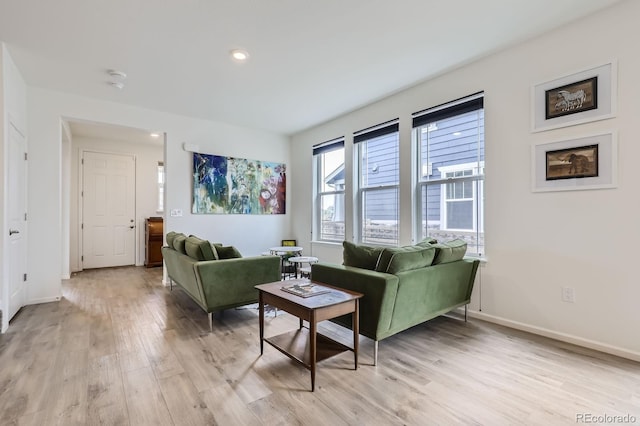living area with recessed lighting, baseboards, and light wood finished floors