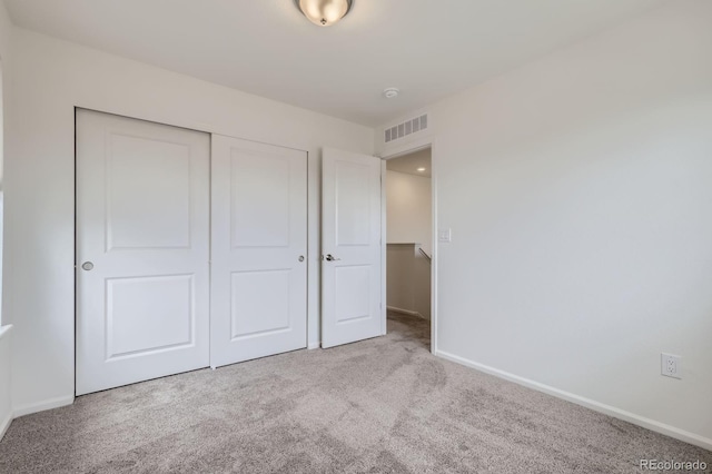 unfurnished bedroom featuring visible vents, carpet, baseboards, and a closet