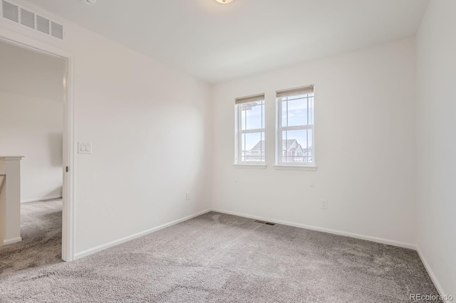 carpeted empty room with visible vents and baseboards