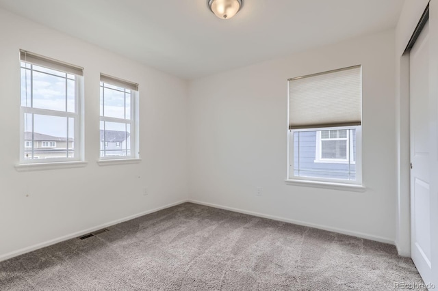 unfurnished room featuring carpet floors, baseboards, and visible vents