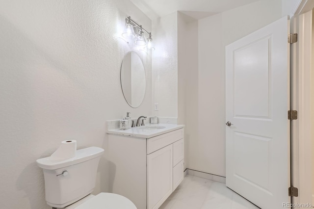 half bathroom featuring toilet, marble finish floor, and vanity