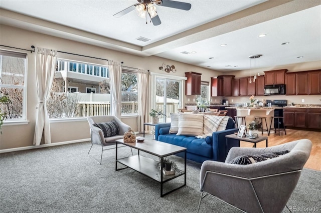 living area with visible vents, ceiling fan, baseboards, light colored carpet, and recessed lighting