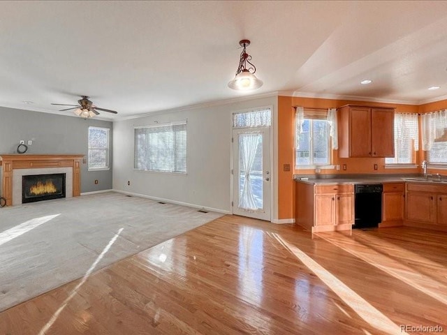 kitchen featuring hanging light fixtures, crown molding, black dishwasher, and sink