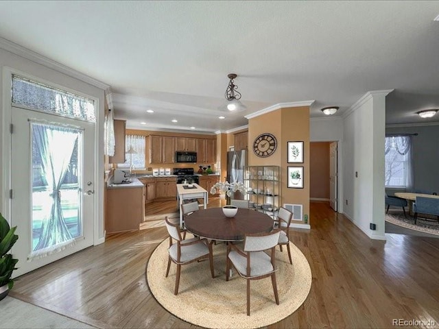 dining room with hardwood / wood-style flooring and ornamental molding