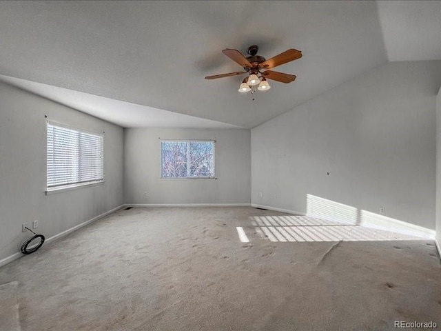 empty room with vaulted ceiling, light colored carpet, and ceiling fan