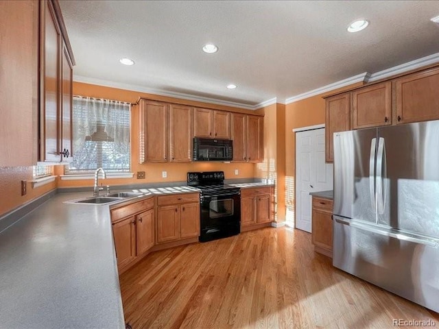 kitchen featuring crown molding, light hardwood / wood-style floors, sink, and black appliances