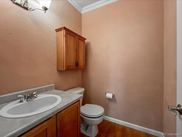 bathroom featuring ornamental molding, toilet, hardwood / wood-style floors, and vanity