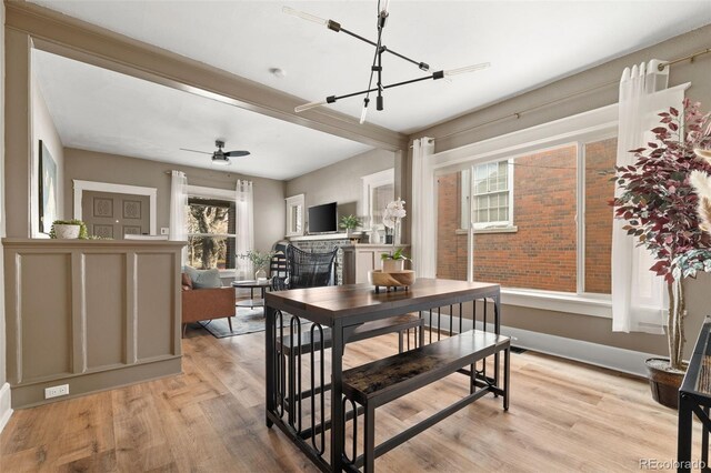 3725 Federal Blvd, Denver, CO 80211 - dining area with light wood-style flooring, a ceiling fan, a chandelier, and a fireplace