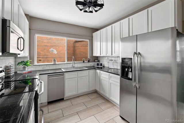 3725 Federal Blvd, Denver, CO 80211 - kitchen featuring appliances with stainless steel finishes, backsplash, dark countertops, and white cabinetry