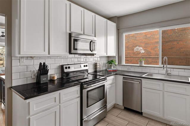 3725 Federal Blvd, Denver, CO 80211 - kitchen featuring stainless steel appliances, backsplash, dark countertops, and white cabinets
